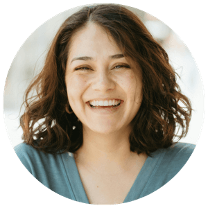 young woman with blue v neck top wavy hair smiling