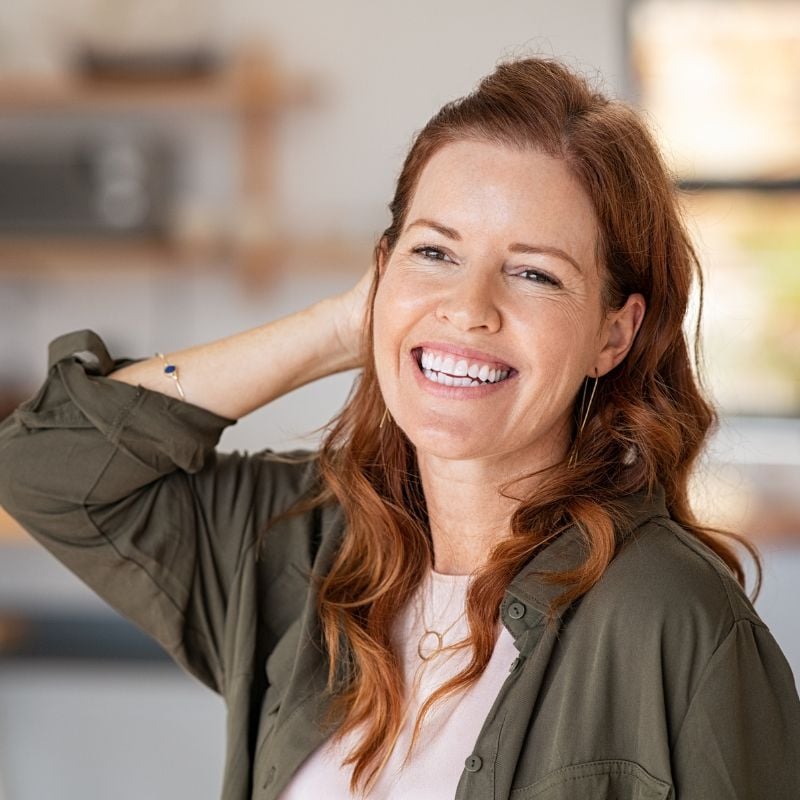 acne-food-allergies-case-study woman smiling tucking hair behind ear