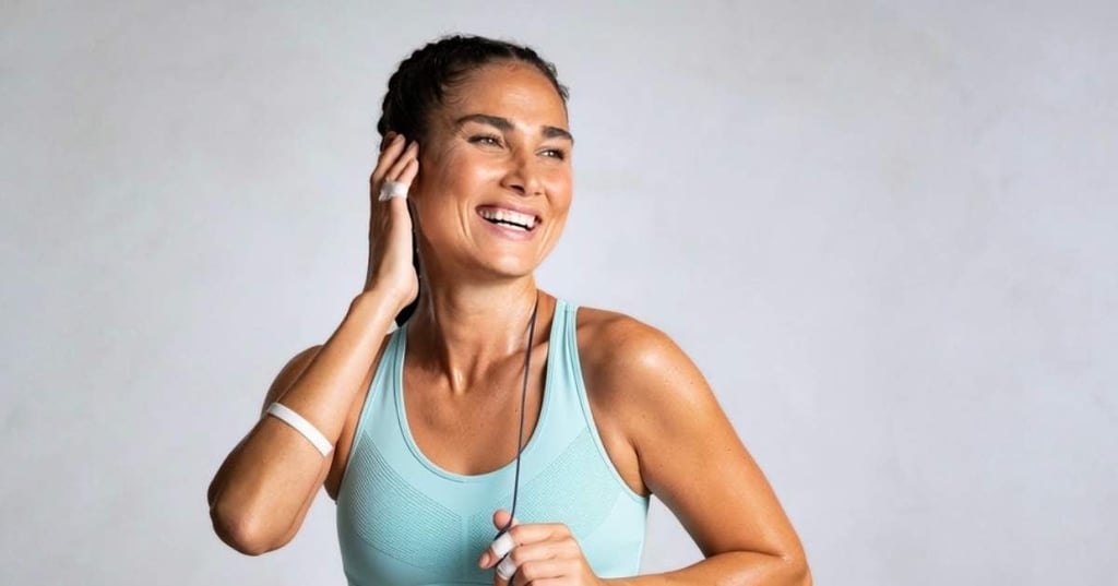 bone-health-women fit woman wearing crop top hand to ear smiling