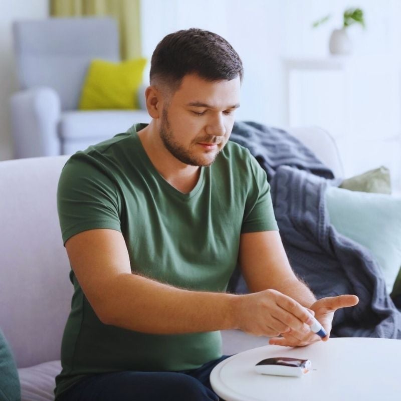 middle aged man with diabetes checking his blood sugar levels with a blood glucose meter