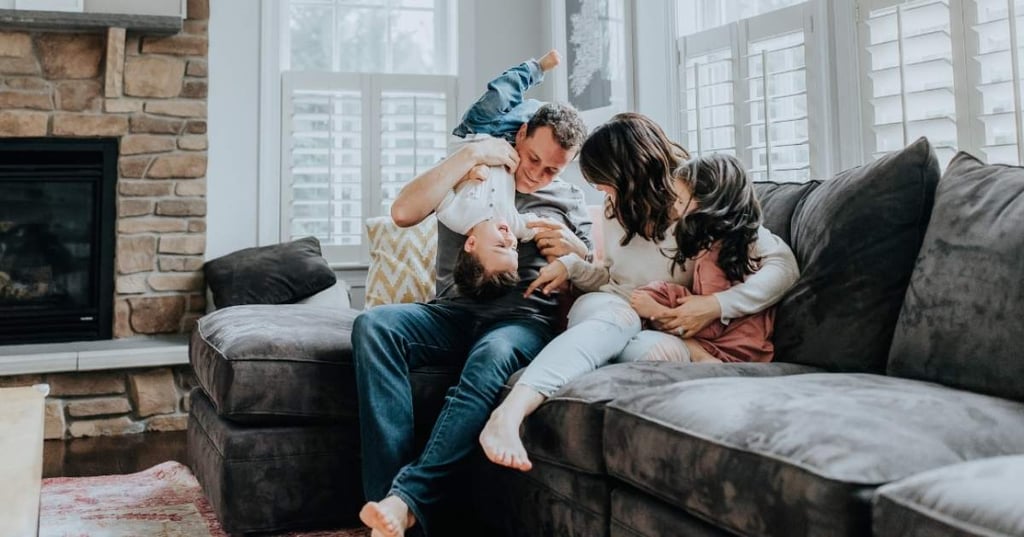 young family sitting together on couch in low tox home