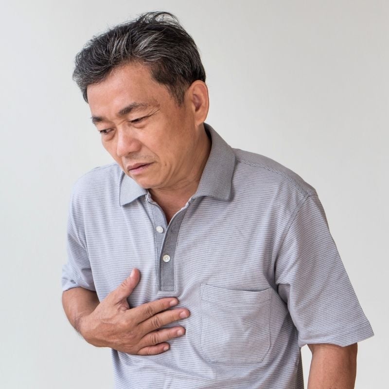 functional-dyspepsia-functional-medicine-hero older man with functional dyspepsia digestive discomfort holding hand to chest