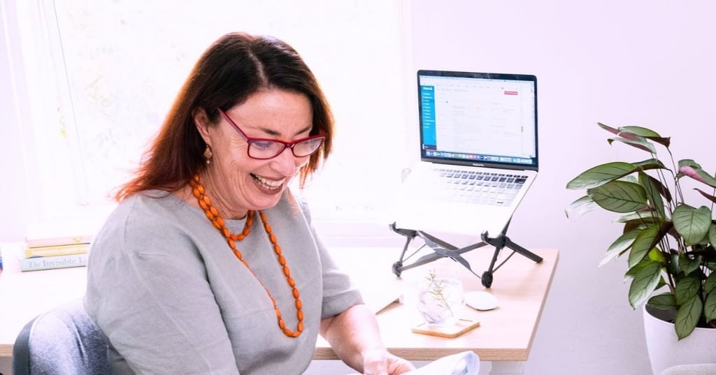 functional-medicine-practitioner-certification-hero functional medicine practitioner sitting at desk smiling reading patient results