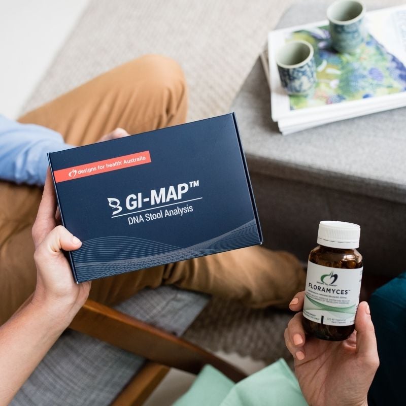 functional medicine practitioner holding gi map dna stool analysis kit practice manager holding floramyces probiotics