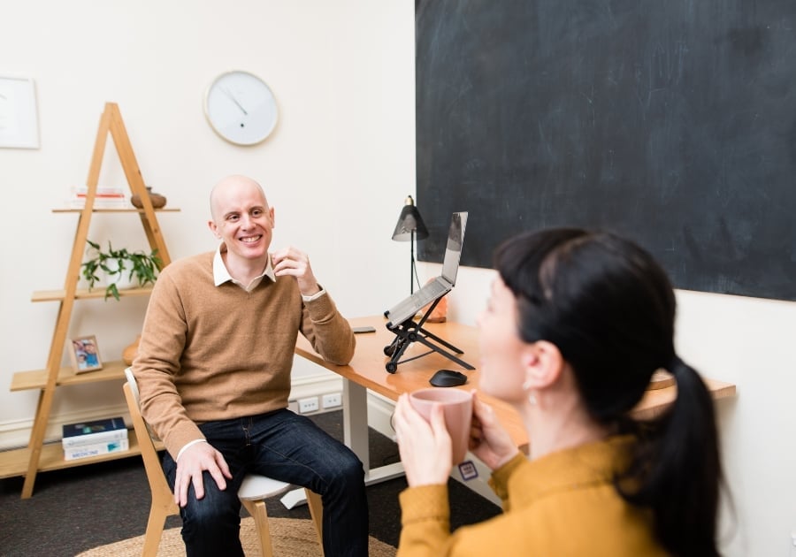jabe-brown-press-consult-clinic-landscape male practitioner sitting in clinic consulting with patient