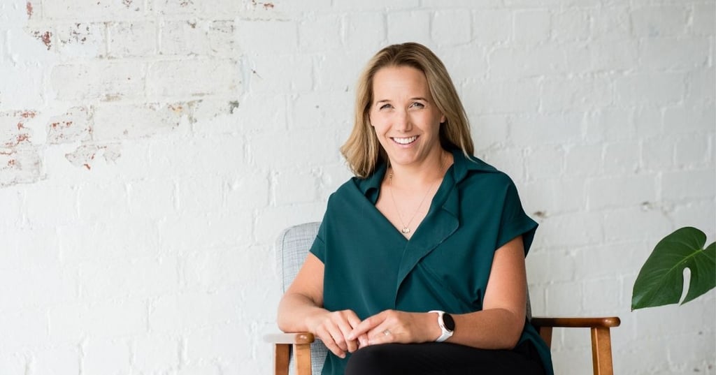 jess-health-coach-of-the-year female health coach sitting in armchair hands resting in lap smiling