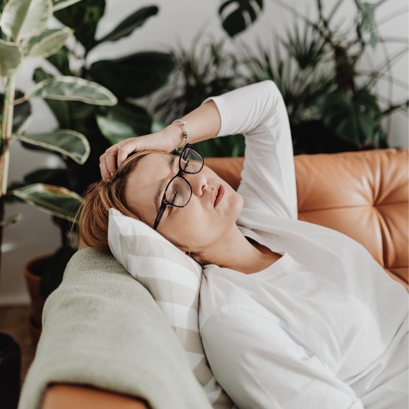 a woman lying on a couch with her head on her hand
