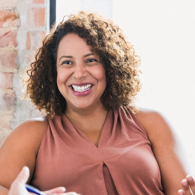 middle aged woman sitting in bright room smiling