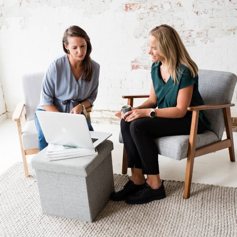 health coaches liv brown jessica cairns looking at laptop discussing wellness goals