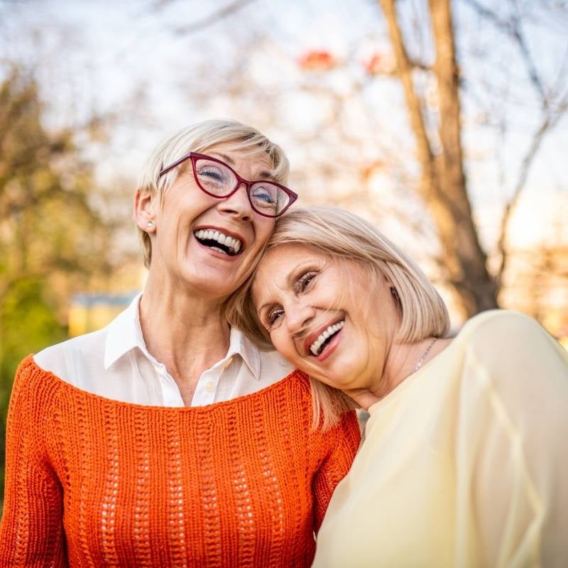 menopause-functional-medicine-condition two mature woman standing outside heads affectionately resting into one another