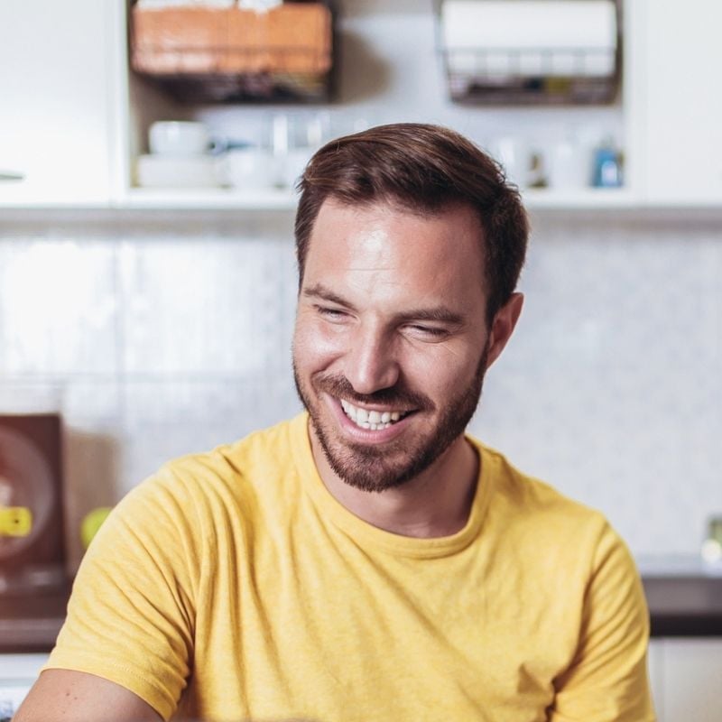 parasites-functional-medicine-hero middle aged man sitting in bright room smiling