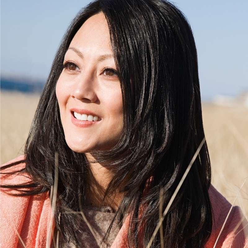 psoriatic-arthritis-functional-medicine-hero woman outside standing in sun smiling