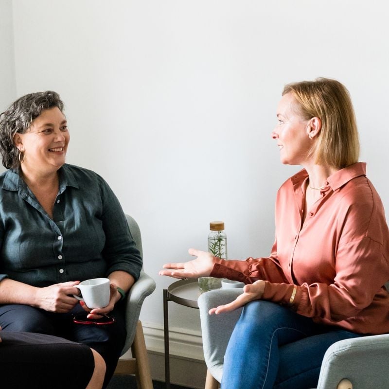 practitioner jabe and health coach bee sitting on a couch discussing lab results.