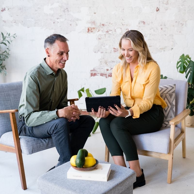 practitioner jabe and health coach bee sitting on a couch discussing lab results.