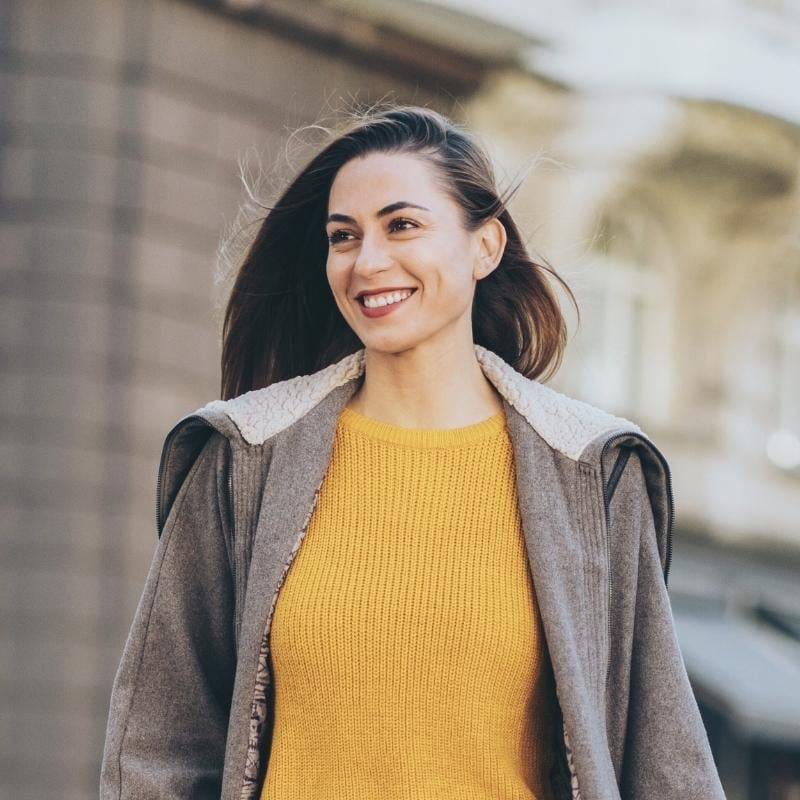 middle aged woman wearing warm jacket outside smiling