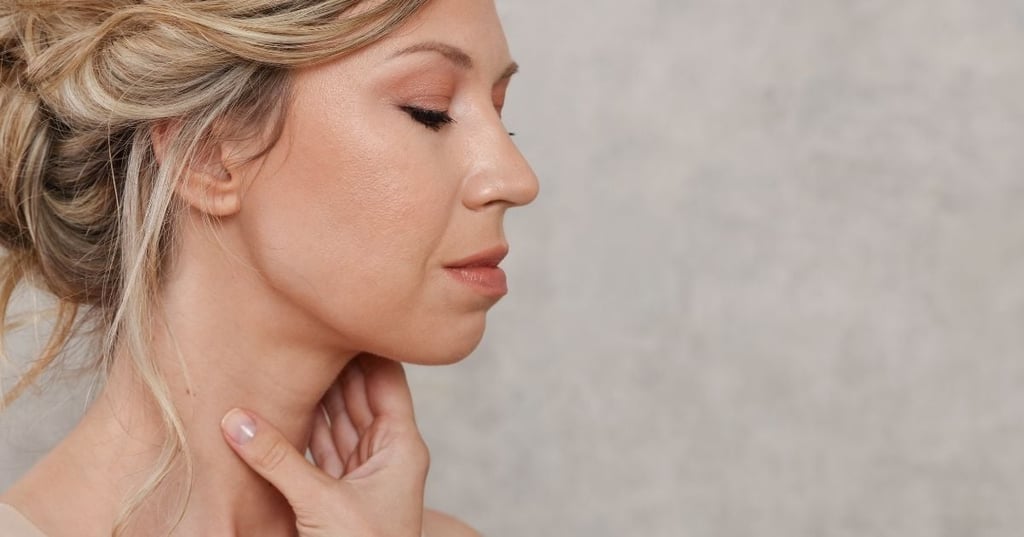 side profile middle aged woman look downward holding front of neck
