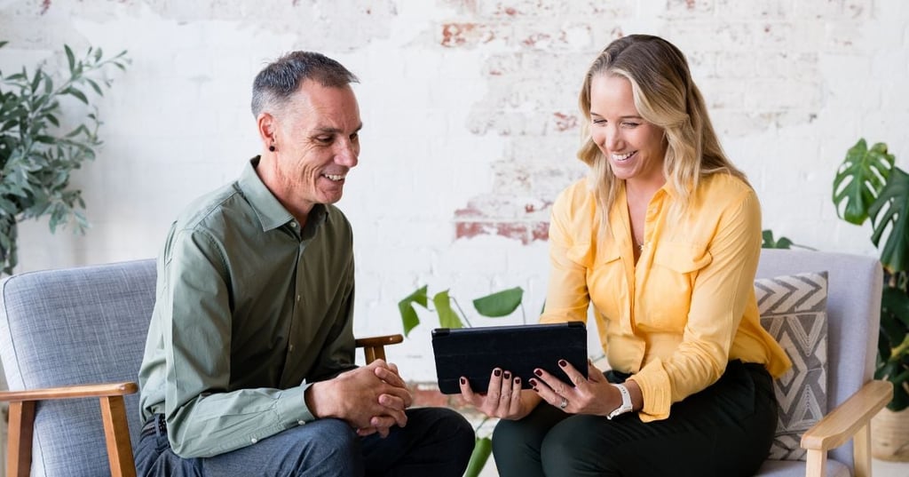 melbourne-functional-medicine-about-open-graph male practitioner sitting in clinic looking at laptop smiling