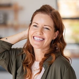 woman smiling tucking hair behind ear