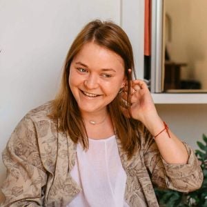woman in living room smiling tucking hair behind ear