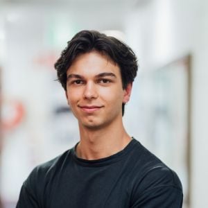 young male in black tshirt smiling