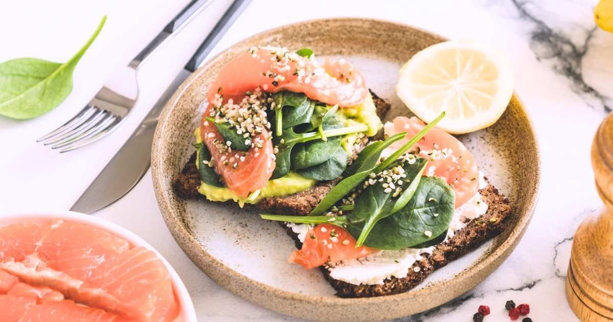 plate of high histamine foods smoked salmon smashed avocado spinach on toast