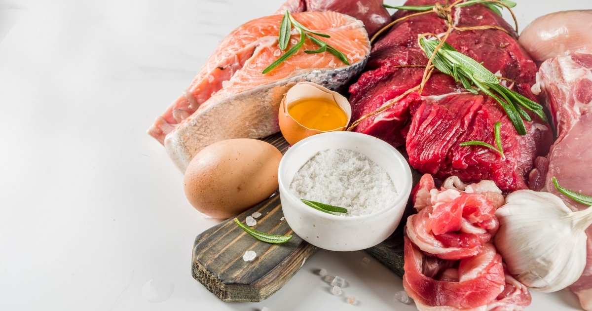 protein rich raw food sources steak salmon eggs on wooden board