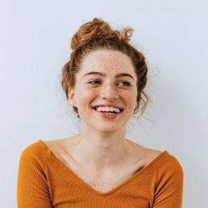profile young woman healthy skin hair tied up smiling glancing off to the side