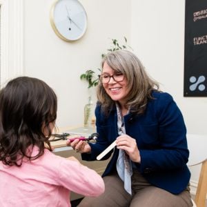rebecca hughes functional medicine practitioner smiling checking childs health in clinic